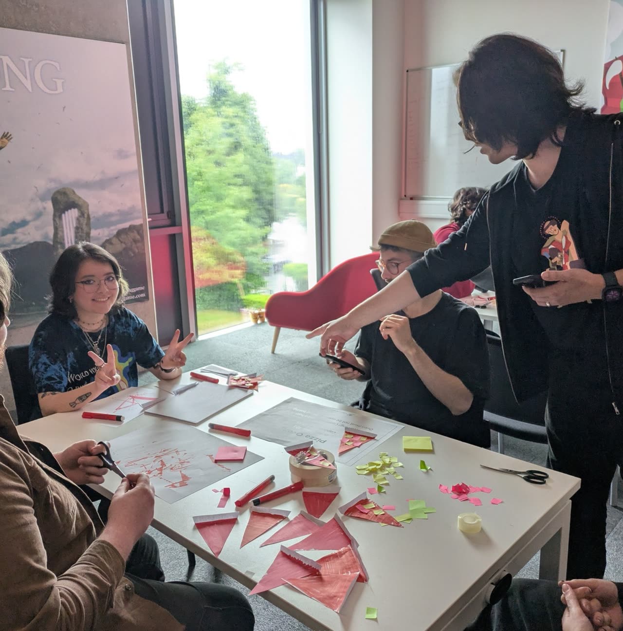 Participants cutting and arranging paper components during a workshop exercise.